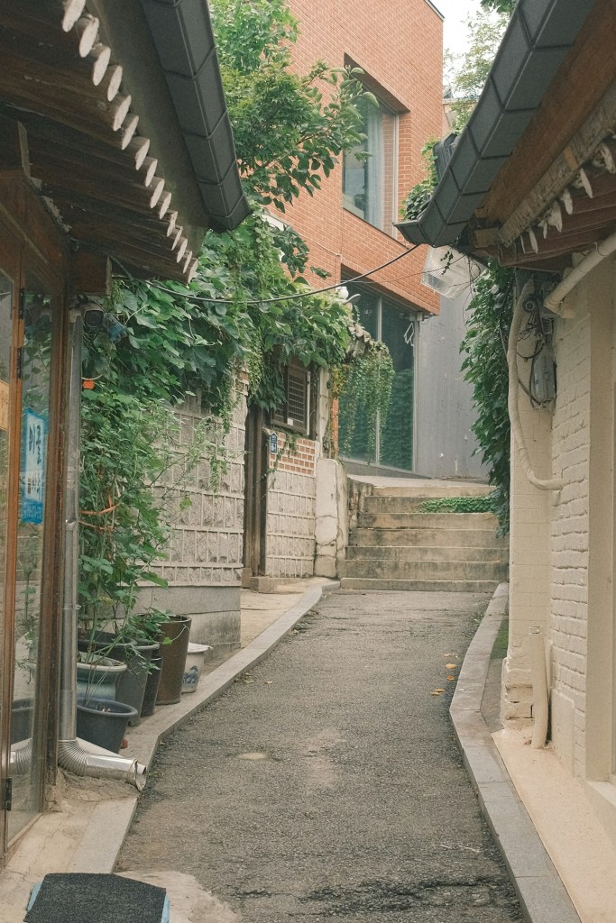 Quiet alleyway in Bukchon Hanok Village with traditional Korean houses and greenery