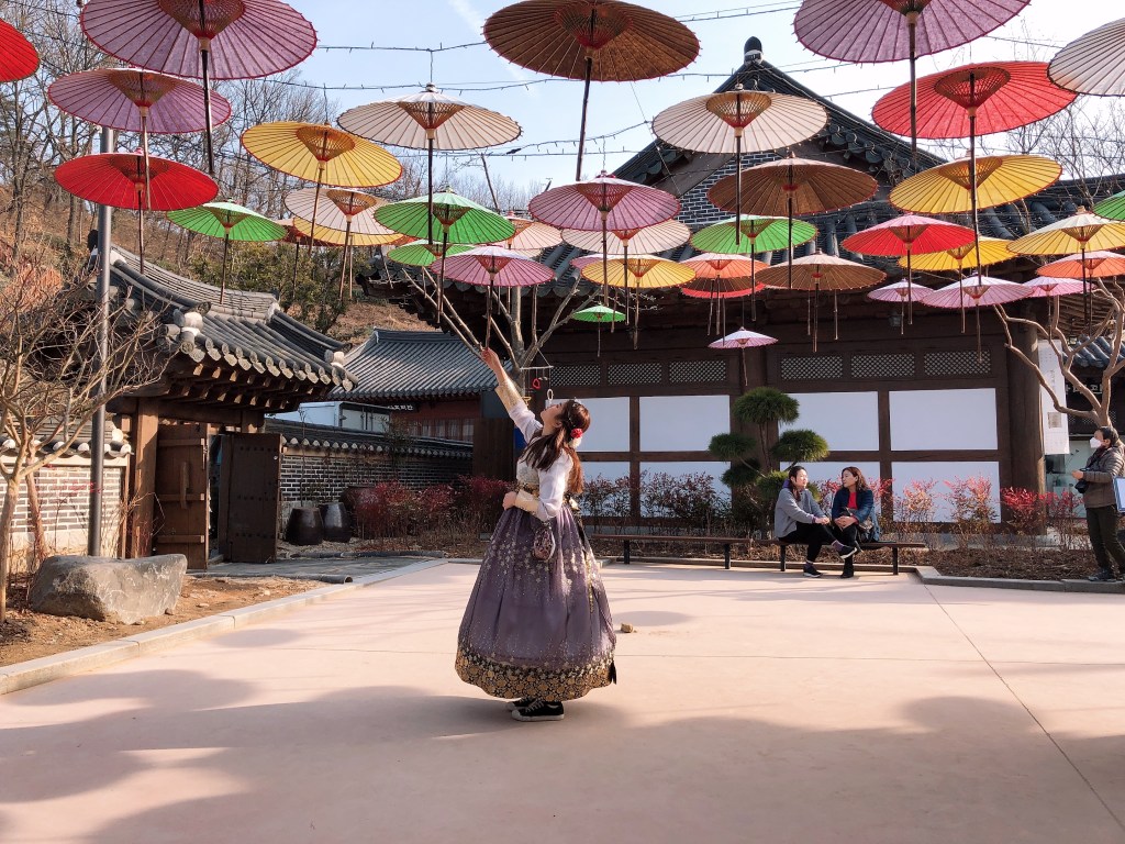 Serene moment of a traveler in hanbok admiring a hanok house in the old village of Seoul